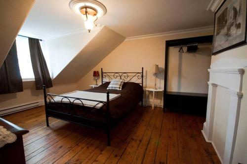 una camera con un letto in una stanza con pavimenti in legno di Heritage Townhouse in Downtown Halifax a Halifax