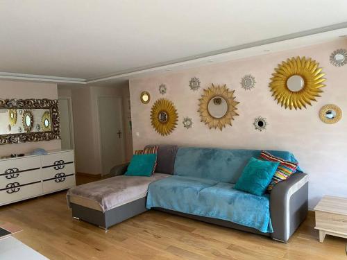 salon z kanapą i lustrami na ścianie w obiekcie Cagnes-sur-Mer, 50m de la mer, au calme w Cagnes-sur-Mer