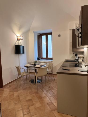 a kitchen and dining room with a table and chairs at IN MEDIA URBE - intero appartamento in LʼAquila