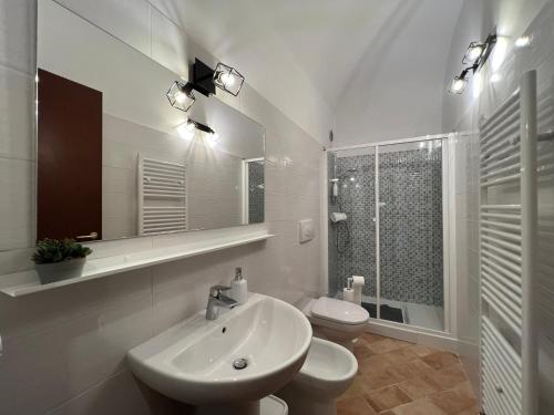 IN MEDIA URBE - intero appartamento في لاكويلا: حمام أبيض مع حوض ومرحاض