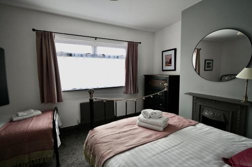 sypialnia z łóżkiem, lustrem i oknem w obiekcie Emerson - homely 3 bedroom sleeps 6 Free Parking & WiFi w mieście Woodhorn