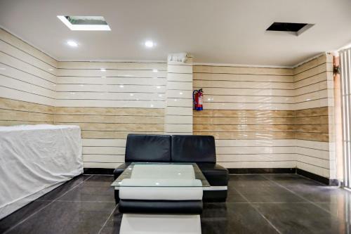 a waiting room with a couch and a wall at OYO Anshun Residency Near M2k Cinemas Rohini in New Delhi
