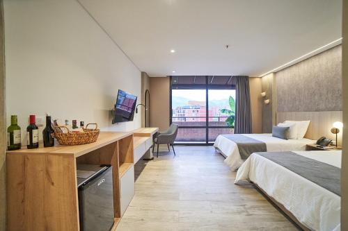 a hotel room with two beds and a television at Eutopiq Hotel in Medellín