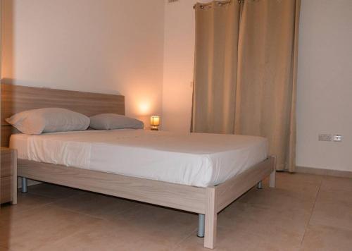 um quarto com uma cama grande e uma cabeceira em madeira em Central Modern Apartment 1 Bedroom em Il-Gżira