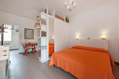 um quarto com uma cama laranja e uma mesa em L'Attichetto di Ponte Milvio em Roma
