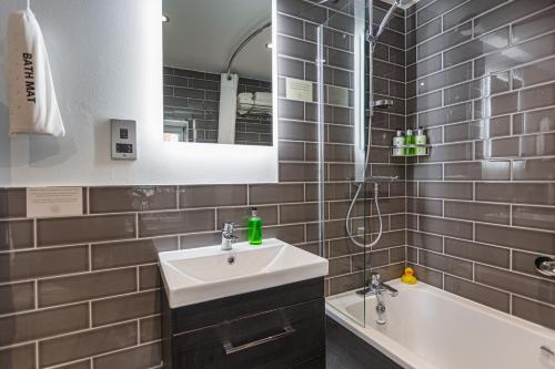 a bathroom with a sink and a shower and a tub at The Manor Coastal Hotel & Inn, Blakeney - part of The Coaching Inn Group in Blakeney