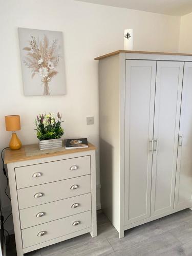 a bedroom with a white cabinet and a dresser at Gatwick Studio in Horley