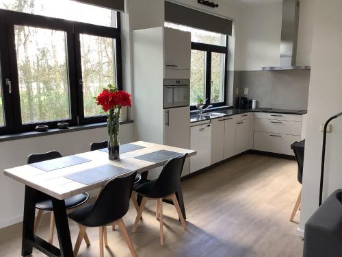 uma cozinha com uma mesa com um vaso de flores em Vakantiewoningeikenhof em Londerzeel