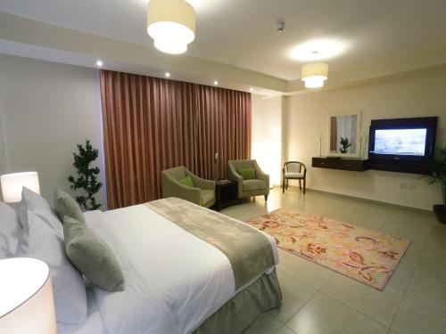 a hotel room with a bed and a living room at City Rose Hotel Suites in Amman