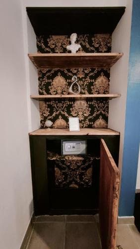 a shelf with a clock on it in a room at L'Empire D'Essences Appartement in Valréas