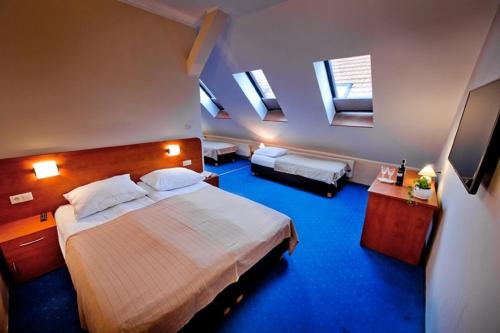 a bedroom with a large bed and two windows at HL Łebski Apartamenty in Łeba