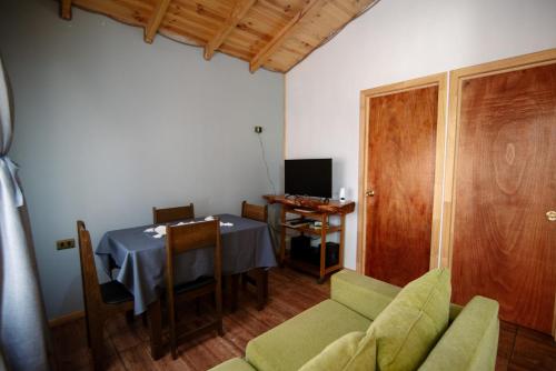 een woonkamer met een tafel en een stoel bij cabañas camino al totoral in El Quisco