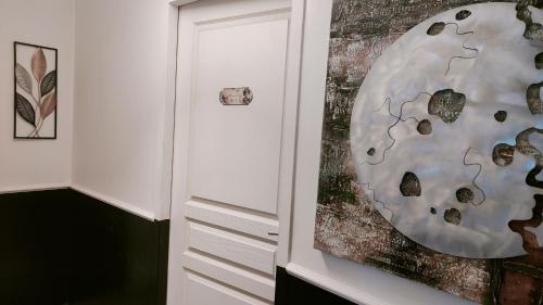 a painting of a moon on a wall next to a door at L'Empire D'Essences Appartement in Valréas