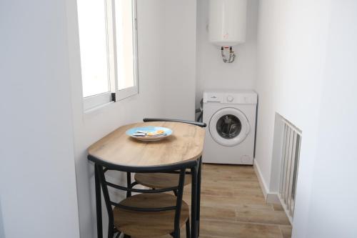 a small kitchen with a table and a washing machine at SDH apartments in Alicante