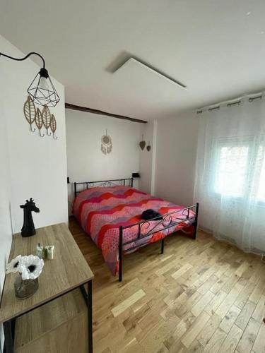 a bedroom with a bed with a red comforter at les jardins d'Holly in Avesnes-en-Bray