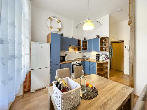 a kitchen with blue cabinets and a wooden table at Laura´s Apartment in Karlovy Vary