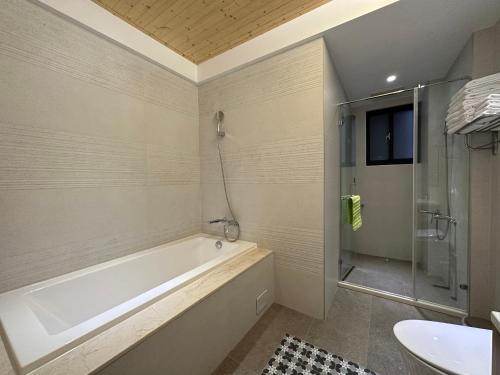 a bathroom with a tub and a shower and a sink at Kaohsiung High Fun Hostel in Kaohsiung