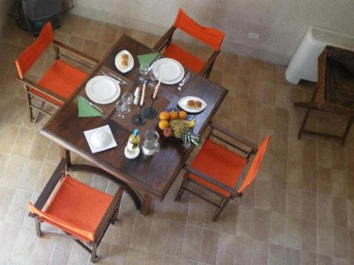 - une table à manger avec des chaises orange dans l'établissement Residence Posillipo, à Naples