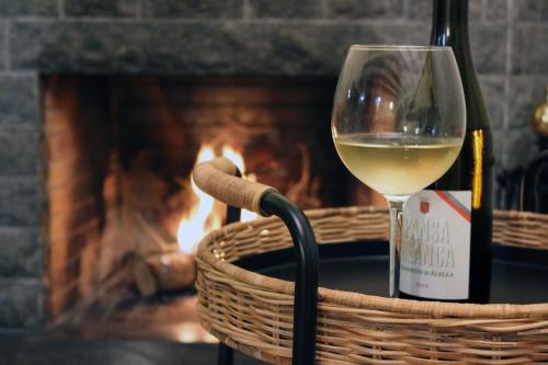 a glass of white wine sitting next to a fireplace at ‘El racó del bandoler’ in Viladrau