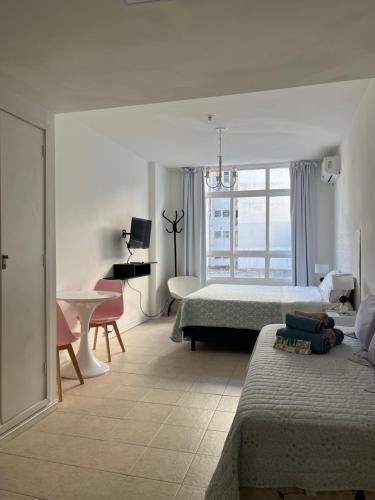 1 dormitorio con 2 camas, mesa y escritorio en Clover Apartment Studio en Buenos Aires