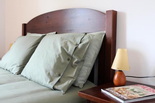 a bed with a wooden headboard and a table with a lamp at ‘El racó del bandoler’ in Viladrau