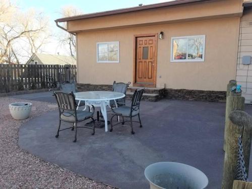 Your home in Colorado Springs في كولورادو سبرينغز: فناء به طاولة وكراسي أمام المنزل