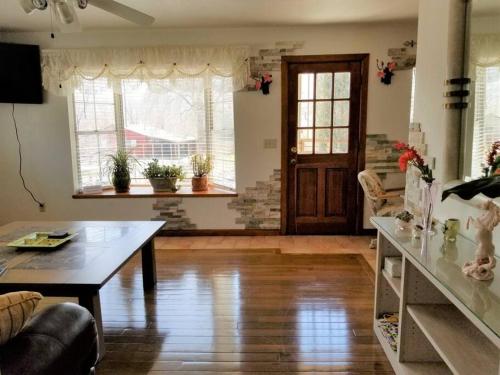 Your home in Colorado Springs في كولورادو سبرينغز: غرفة معيشة مع طاولة وبعض النوافذ