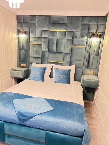 ein Schlafzimmer mit einem großen Bett mit blauen Kissen in der Unterkunft Milena Studio 1 Dormitor in Bukarest