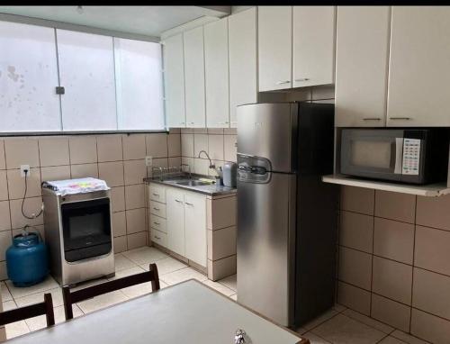 a kitchen with a stainless steel refrigerator and a microwave at Apartamento 2 quartos Setor Sul in Goiânia