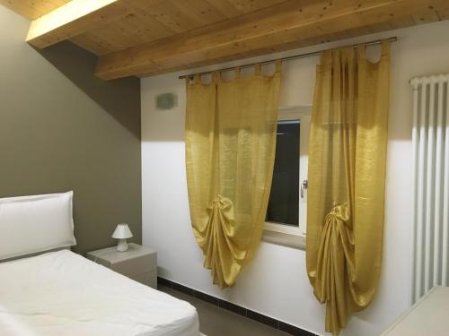 a bedroom with a bed and a window with curtains at L'Alfiere 2 in Corato