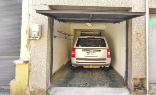 a white car is parked in a garage at House with large terrace, jacuzzi and gated parking for one car in Montevideo