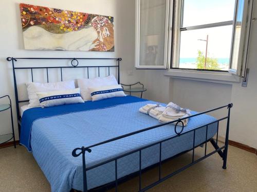 - une chambre avec un lit avec une couette bleue et 2 fenêtres dans l'établissement SeaSound Casa Vacanze, à Rimini