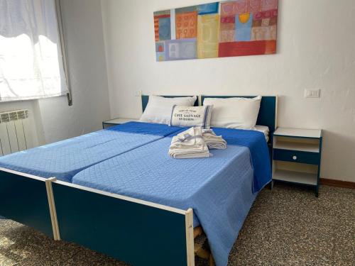 - un lit bleu dans une chambre avec deux tables dans l'établissement SeaSound Casa Vacanze, à Rimini