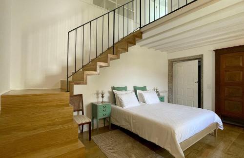 a bedroom with a bed and a staircase at Casa da Agrela in Ponte da Barca