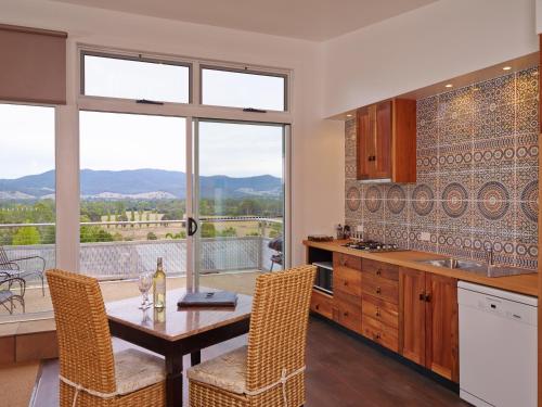 a kitchen with a table and chairs with a view at Panoramia Villas in Myrtleford