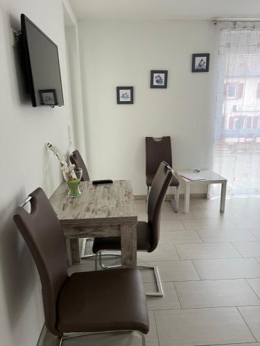 a dining room with a table and chairs and a tv at Kiefer-Apartments in Rust