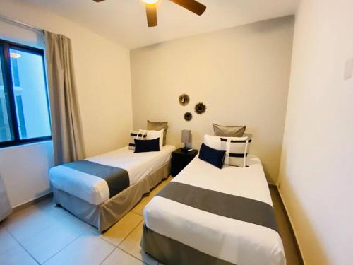 ein Hotelzimmer mit 2 Betten und einem Fenster in der Unterkunft COZY UNIT at Bambu Residencial & AMAZING POOL in Puerto Vallarta