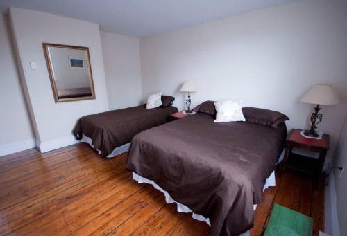 a hotel room with two beds and a mirror at Heritage Row House in Downtown Halifax in Halifax