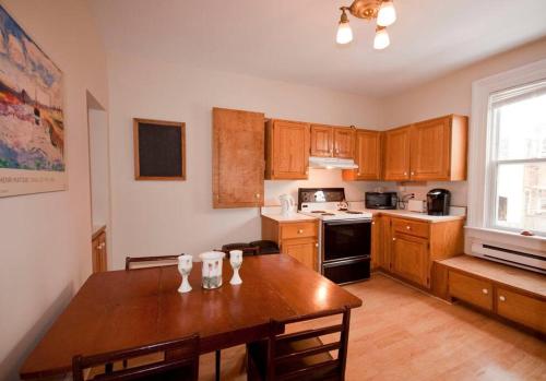 a kitchen with wooden cabinets and a wooden table at Heritage Row House in Downtown Halifax in Halifax