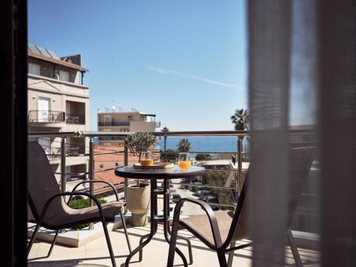 a balcony with a table and chairs and a view of the ocean at Laura Suites in Zakynthos Town