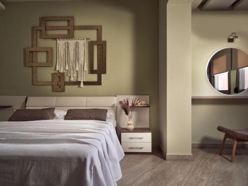 a bedroom with a large bed and a mirror at Laura Suites in Zakynthos Town