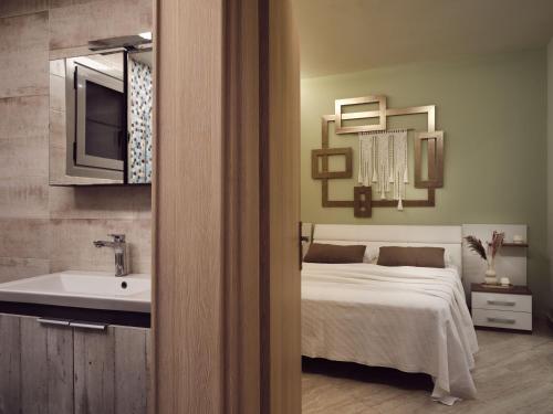a bedroom with a bed and a sink and a mirror at Laura Suites in Zakynthos Town