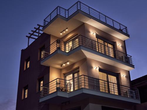 a tall building with balconies and lights on it at Laura Suites in Zakynthos Town
