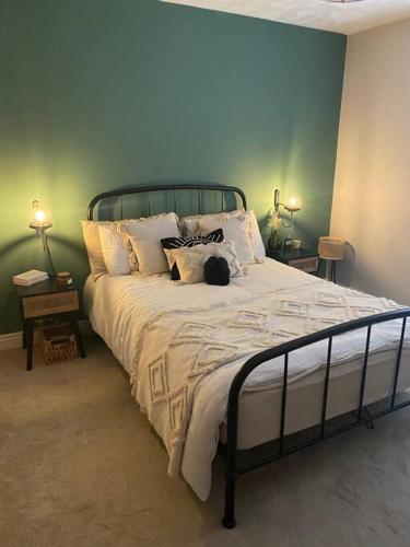 ein Schlafzimmer mit einem großen Bett mit weißer Bettwäsche und Kissen in der Unterkunft Homely 2-bed Terrace with Log Burner in Lincolnshire