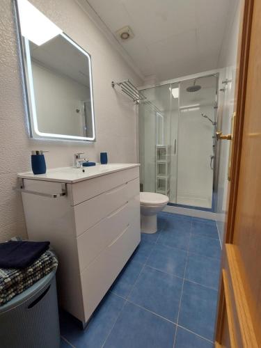 een badkamer met een wastafel, een toilet en een spiegel bij L'EsCALPE BAHIA - full wifi in Calpe