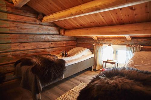 um quarto com uma cama num chalé de madeira em Billingen Seterpensjonat em Skjåk
