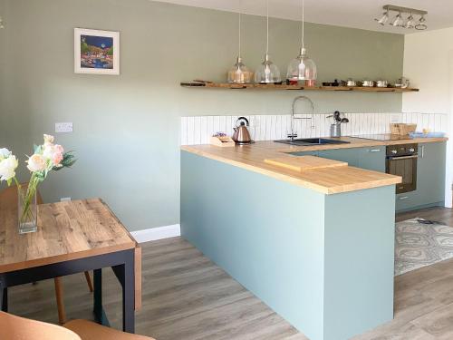 a kitchen with a counter top and a table at Glan Llyn Annex in Whitford