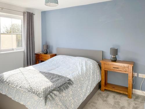 a bedroom with a bed and a table and a window at Glan Llyn Annex in Whitford