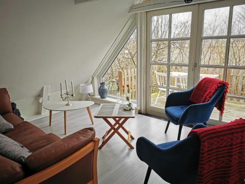 a living room with a couch and chairs and windows at Yogi Wellness Guesthouse in Klagstorp