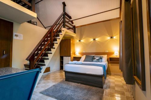 a bedroom with a bed and a staircase at Pousada Villa Pinhal in Santo Antônio do Pinhal